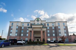 A Holiday Inn Express hotel with a central entrance, multiple parking spaces, and a clear sky. - Holiday Inn Express & Suites Brampton by IHG (Brampton)