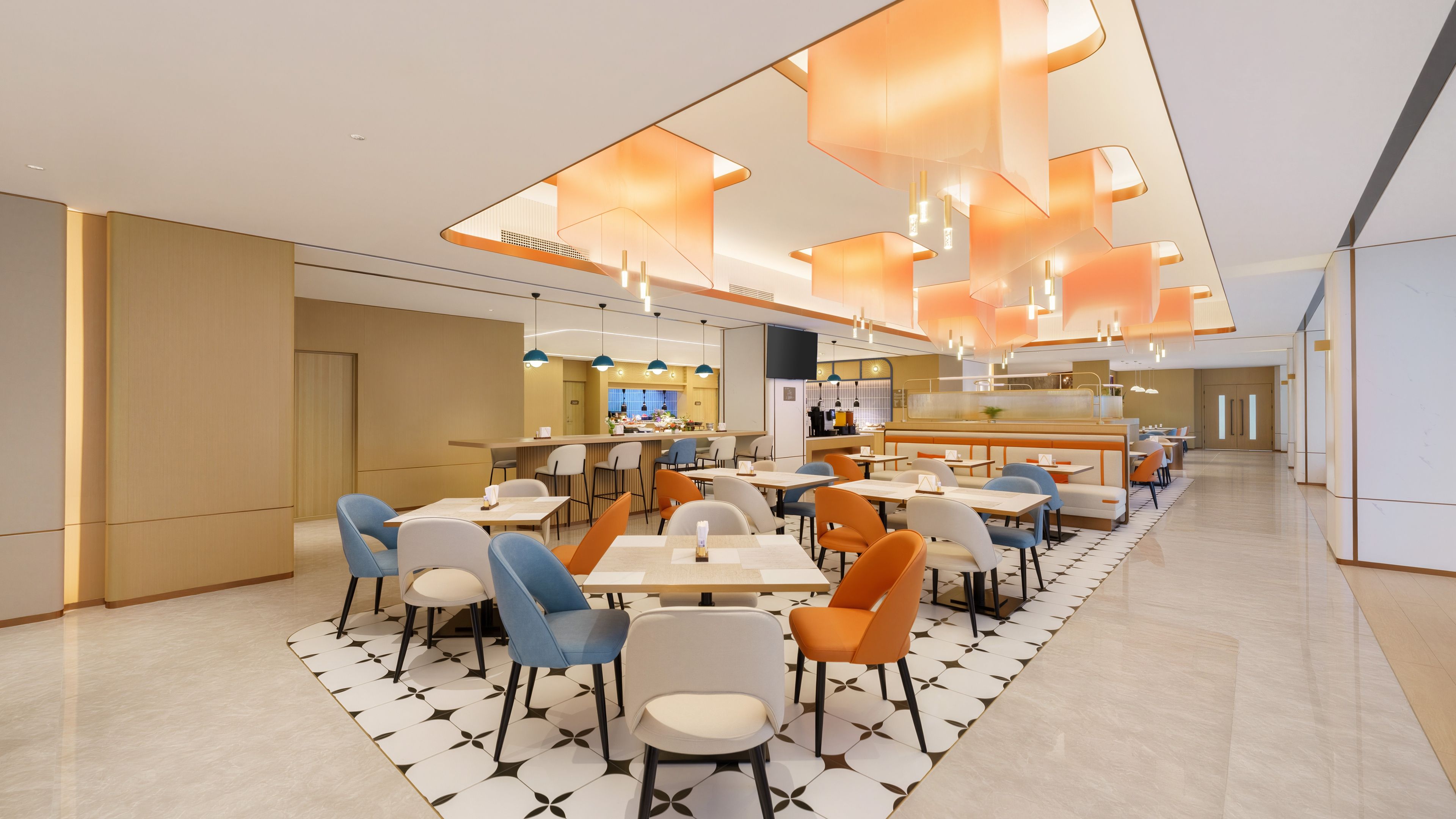 Un restaurante moderno con una barra alargada, varias zonas de estar e iluminación colgante.