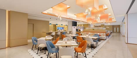 Un restaurante moderno con una barra alargada, varias zonas de estar e iluminación colgante.