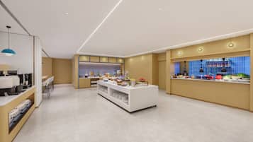 A modern hotel lobby with a reception desk, seating area, and a buffet counter.