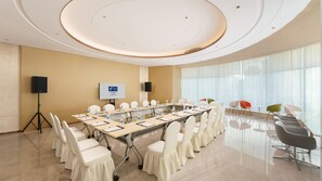 A conference room with a long table, chairs, a speaker, and a screen. - Holiday Inn Express Dalian City Centre by IHG (Dalian)