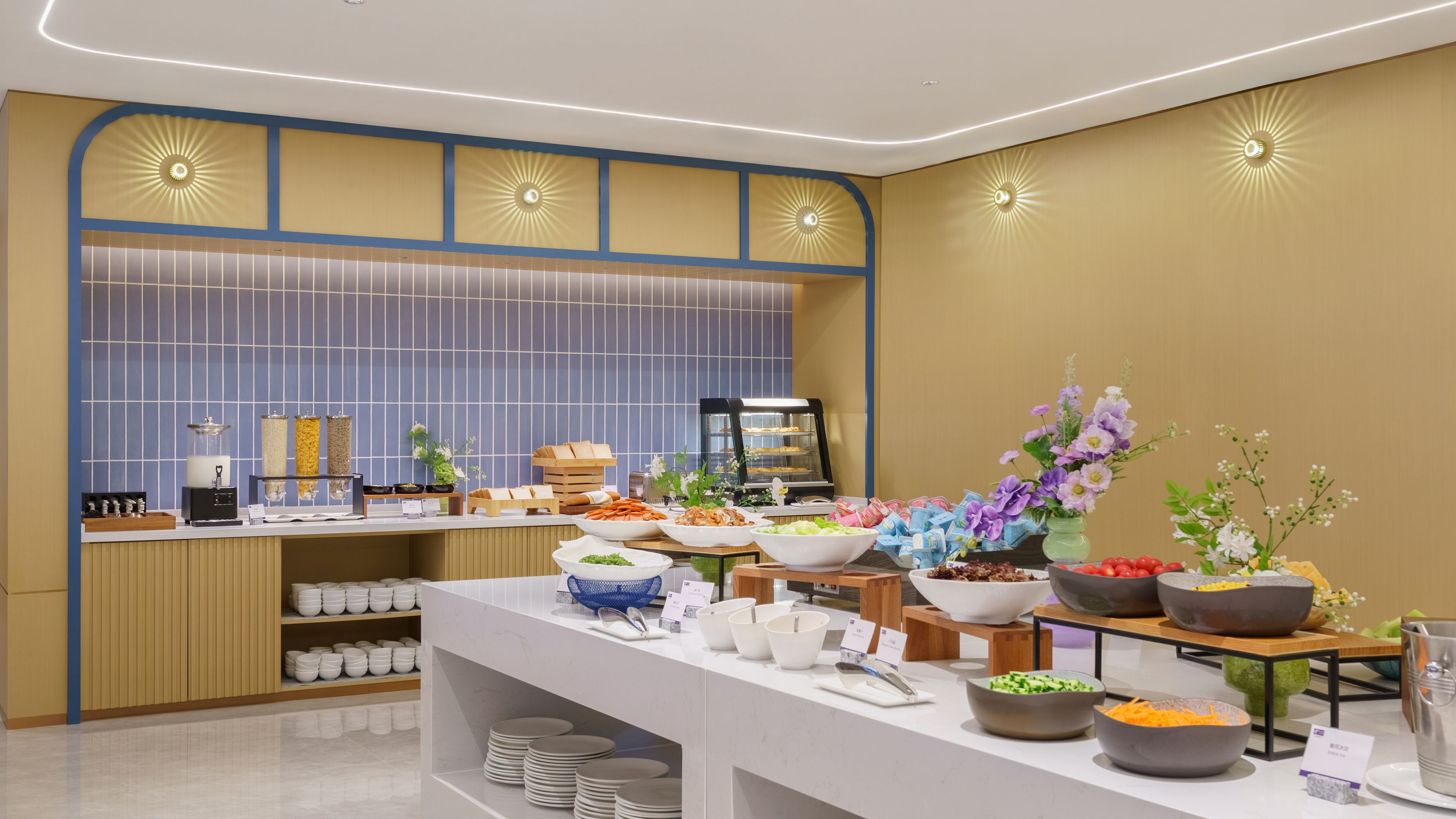 A buffet setup with various food items and a self-service station.