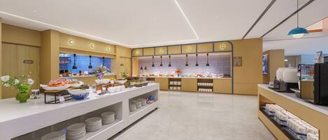 A modern buffet setup with multiple food stations, a coffee machine, and a self-service beverage dispenser.