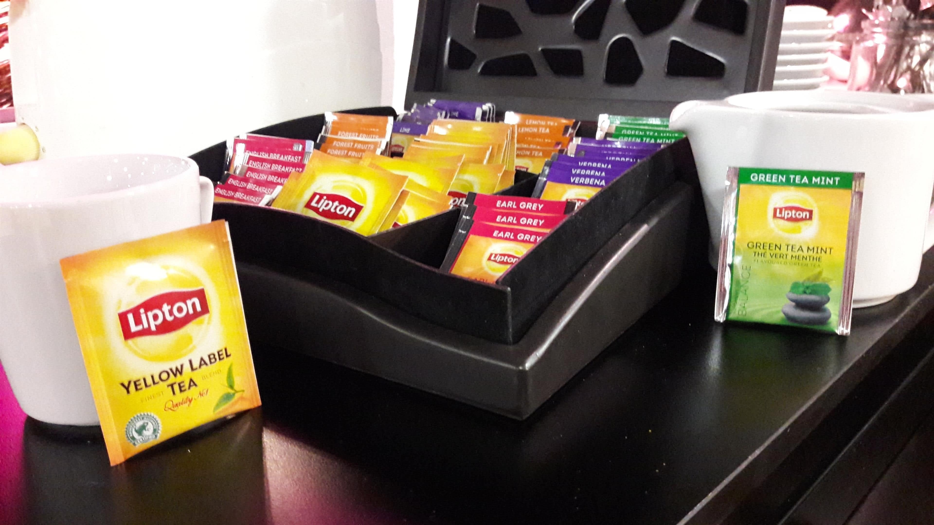 A tea display with various Lipton tea flavors in a black tray.