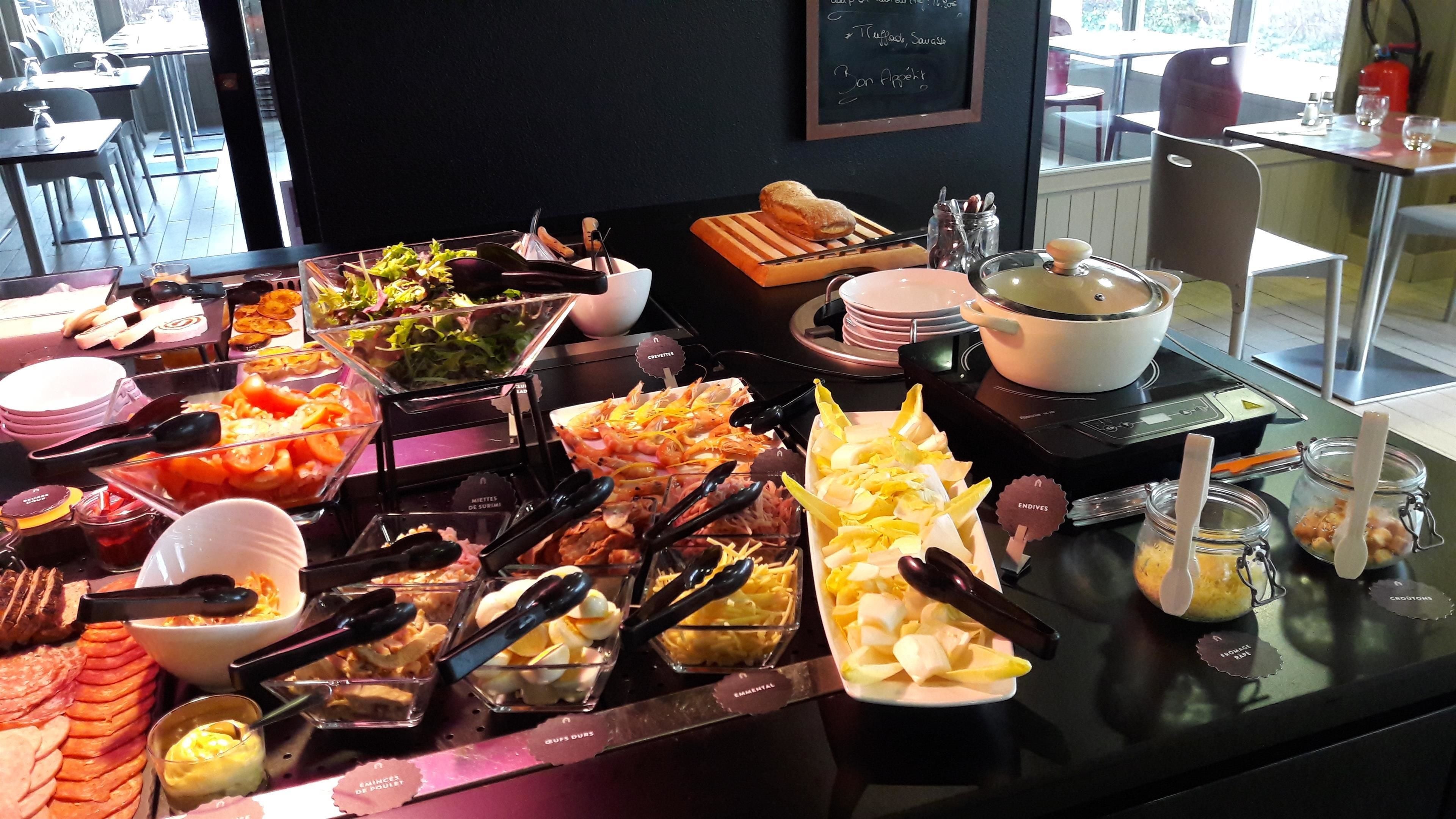 A buffet with various food items and utensils.