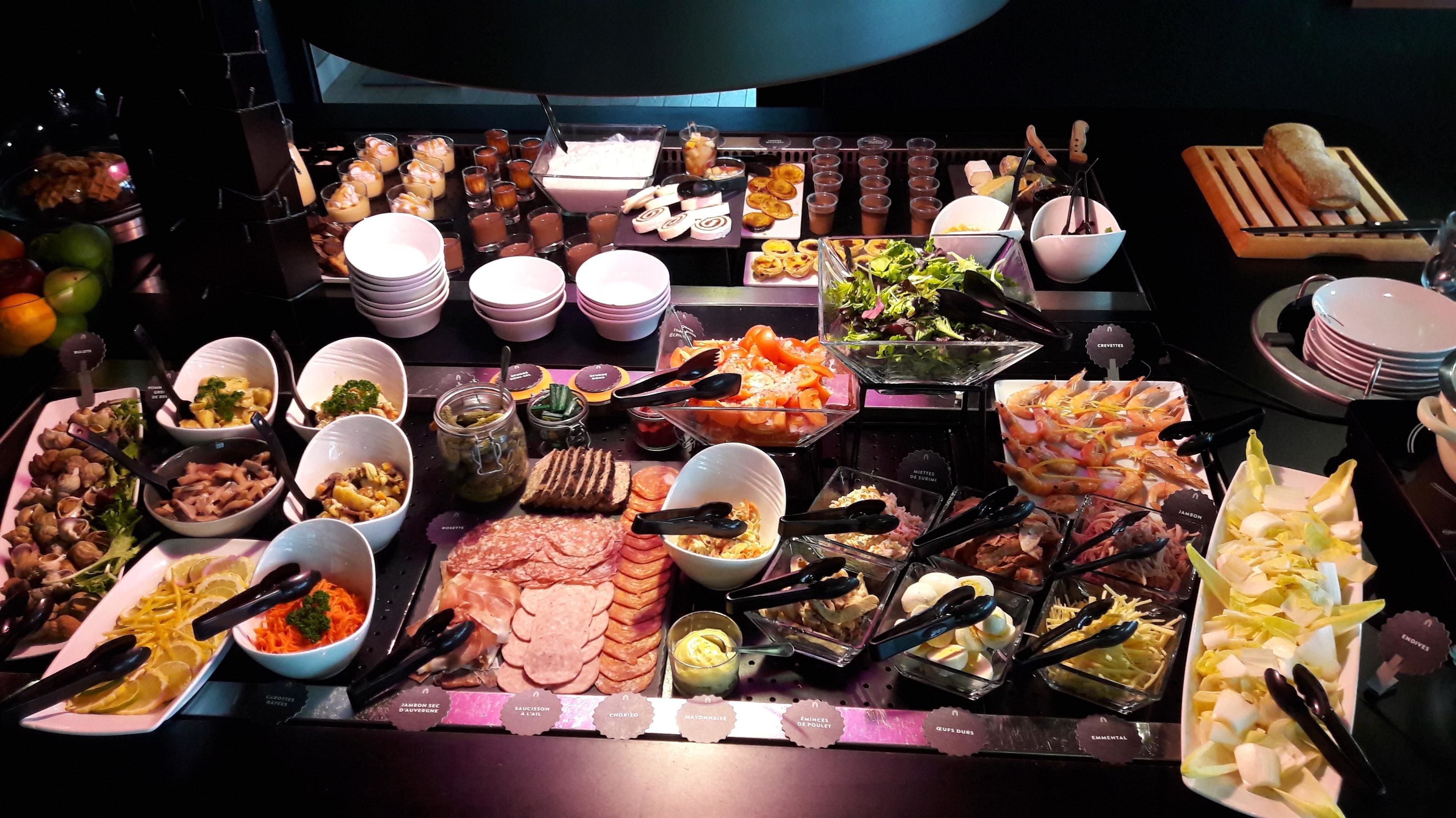 Un buffet proposant une variété de plats et d’ustensiles.