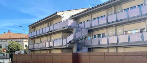 A multi-story building with balconies and a staircase.