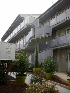 A multi-story building with balconies and a sign indicating age ranges for rooms. - Campanile Albi Centre (Albi)
