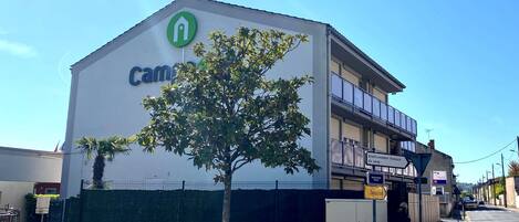 A building with a sign that reads "Cam".