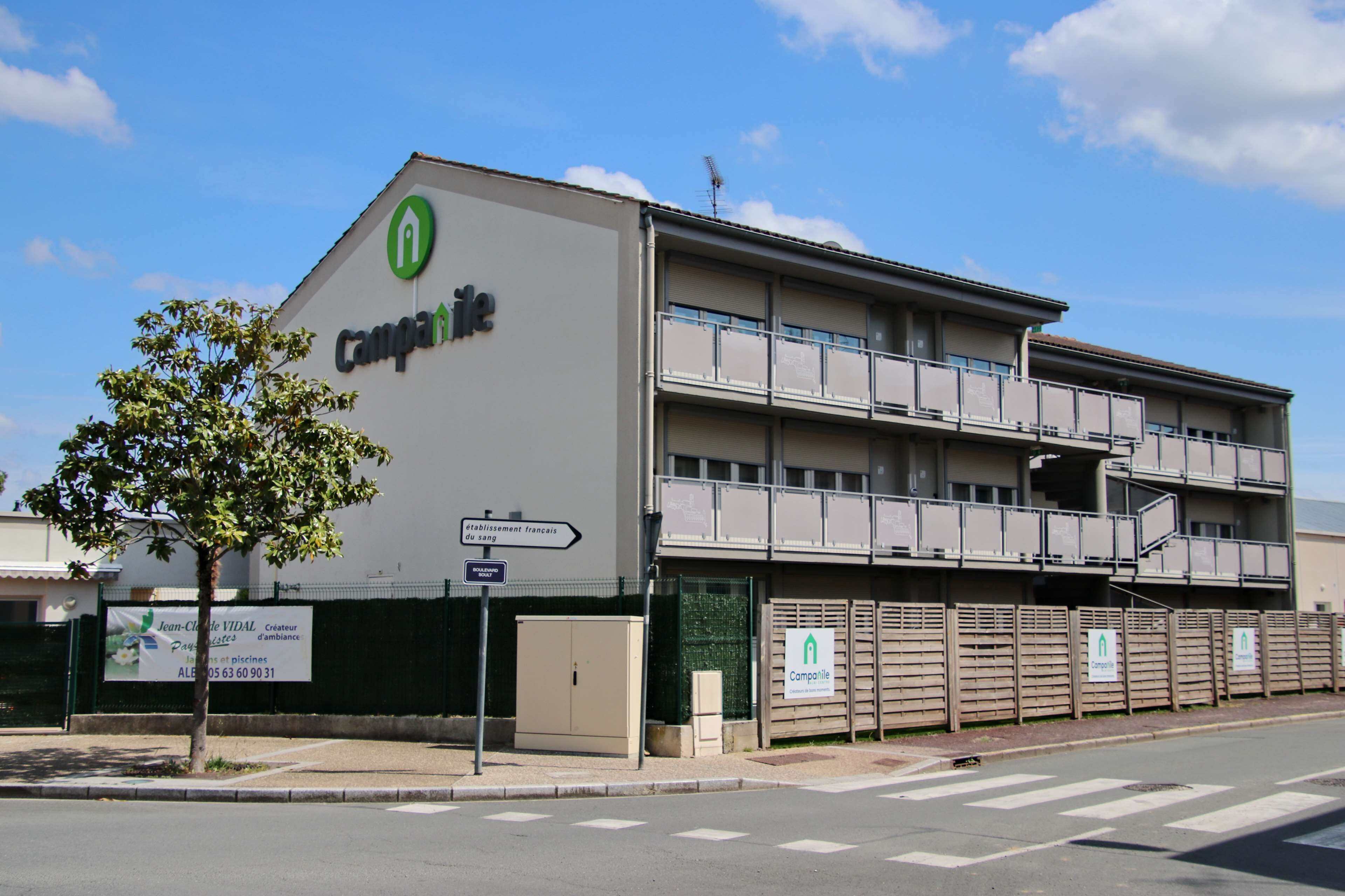 A building with a sign reading "Campanile" and a tree in front.
