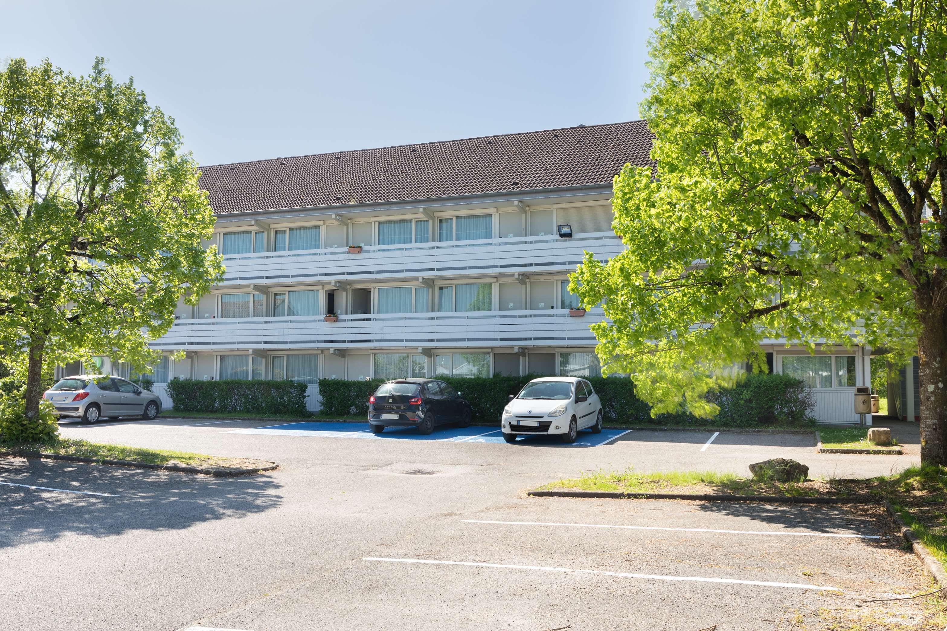 A multi-story residential building with a parking lot.