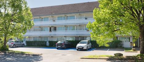 Un immeuble résidentiel à plusieurs étages doté d’un parking.