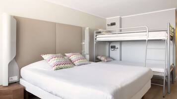 A modern hotel room with a large bed, a bunk bed, and a bedside table.