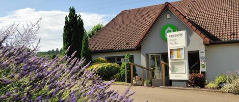 A building with a tiled roof and a sign that reads "Campanile Accueil Restaurant."