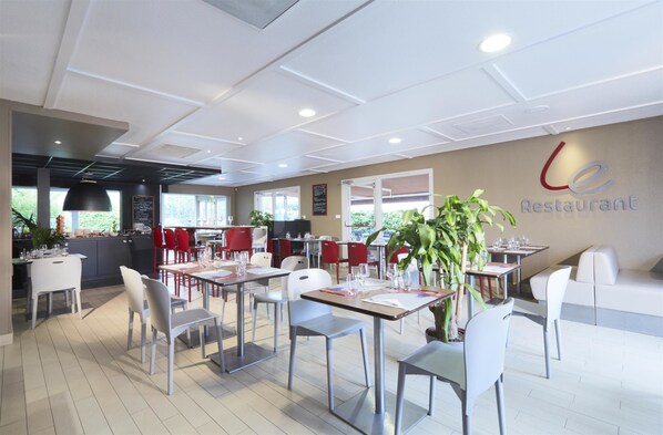 Un restaurante con una decoración moderna, con mesas y sillas dispuestas para comer.