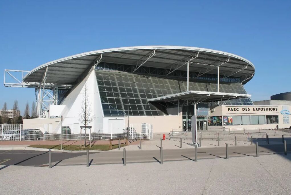 A modern stadium with a curved roof and a sign reading "PARC DES EXPOSITIONS".