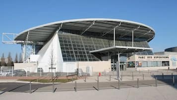 A modern stadium with a curved roof and a sign reading "PARC DES EXPOSITIONS".