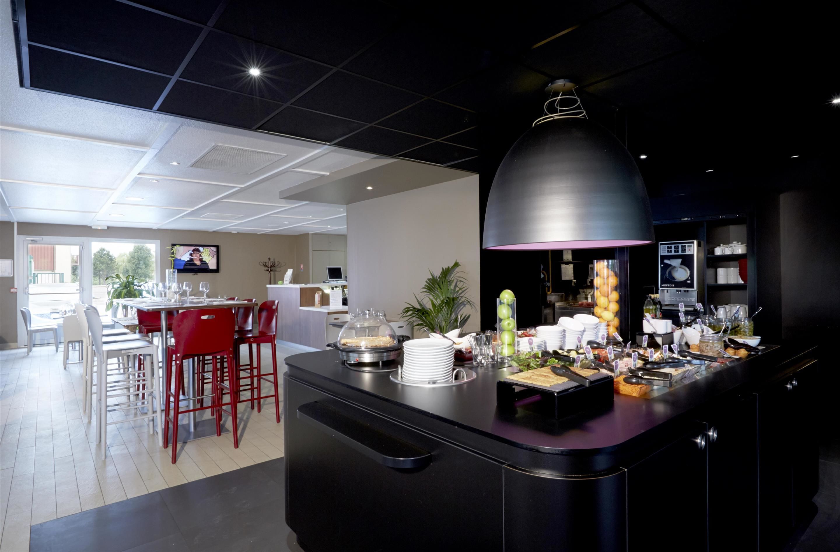 Un comedor moderno con servicio de buffet, que incluye diversos alimentos y una pantalla de televisión.