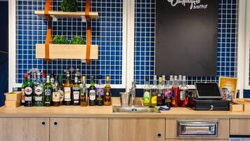A bar area with a variety of liquor bottles, a chalkboard menu, and a laptop on the counter.