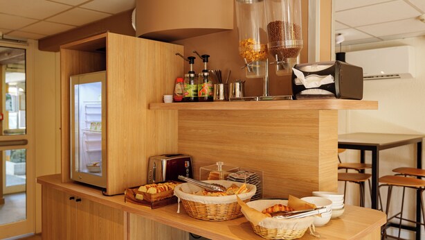Een ontbijtbuffet met een broodrooster, broodbakken en een koffieapparaat.