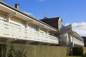 Un edificio moderno con techo plano, ventanas grandes y una antena parabólica.