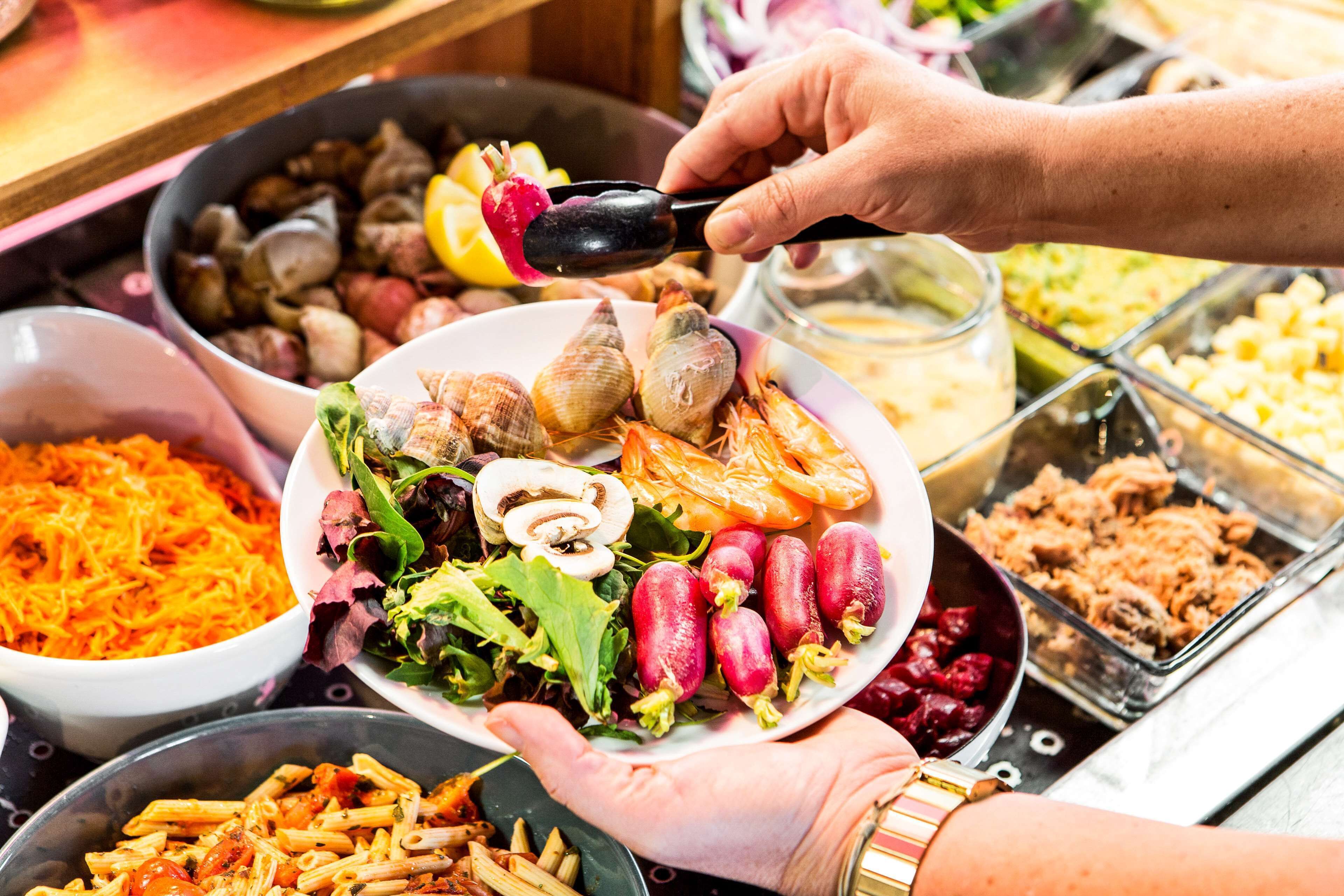 A buffet with various dishes including pasta, salads, and seafood.