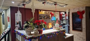 A bar area with a Christmas theme, including decorations like a star ornament, poinsettias, and a Santa hat. - Campanile Saint Quentin (Saint-Quentin)