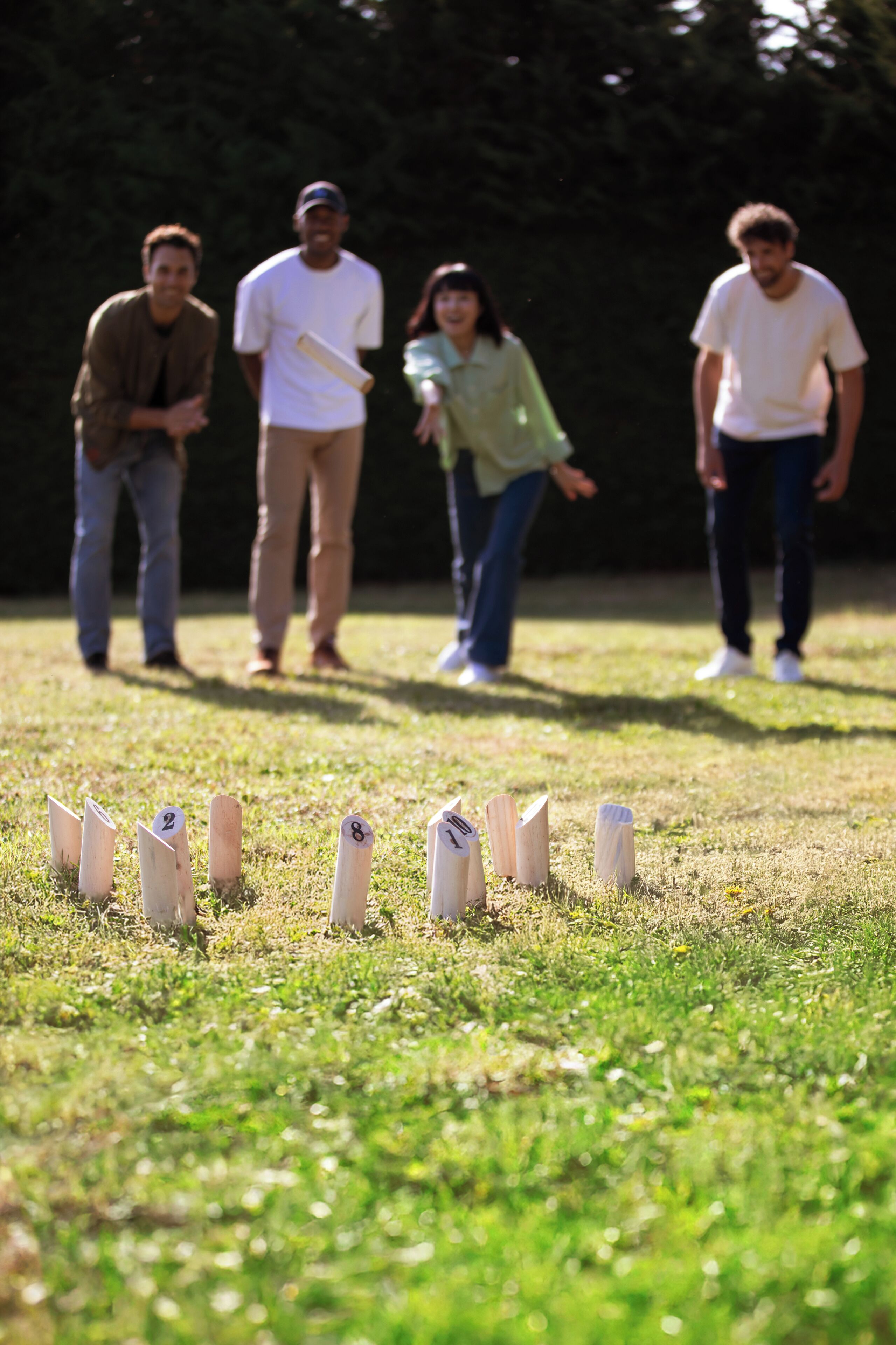 A group of people playing a game with numbered markers on a grassy field.