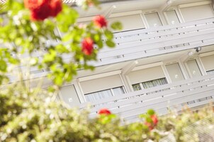 Un immeuble à plusieurs étages, avec des murs extérieurs blancs et de nombreuses fenêtres.