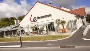 A restaurant with outdoor seating and a red-tiled roof.