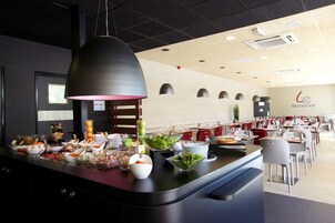 Un buffet proposant divers plats, avec une enseigne de restaurant en arrière-plan.