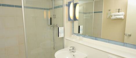 A modern bathroom with a glass-enclosed shower, a white sink, and a large mirror.