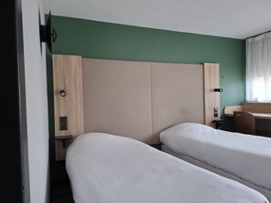A hotel room with two single beds, a desk, and a chair. - Campanile Montbeliard - Sochaux (Sochaux)