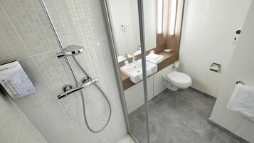 Une salle de bain moderne avec une douche à parois de verre, un lavabo et des toilettes.