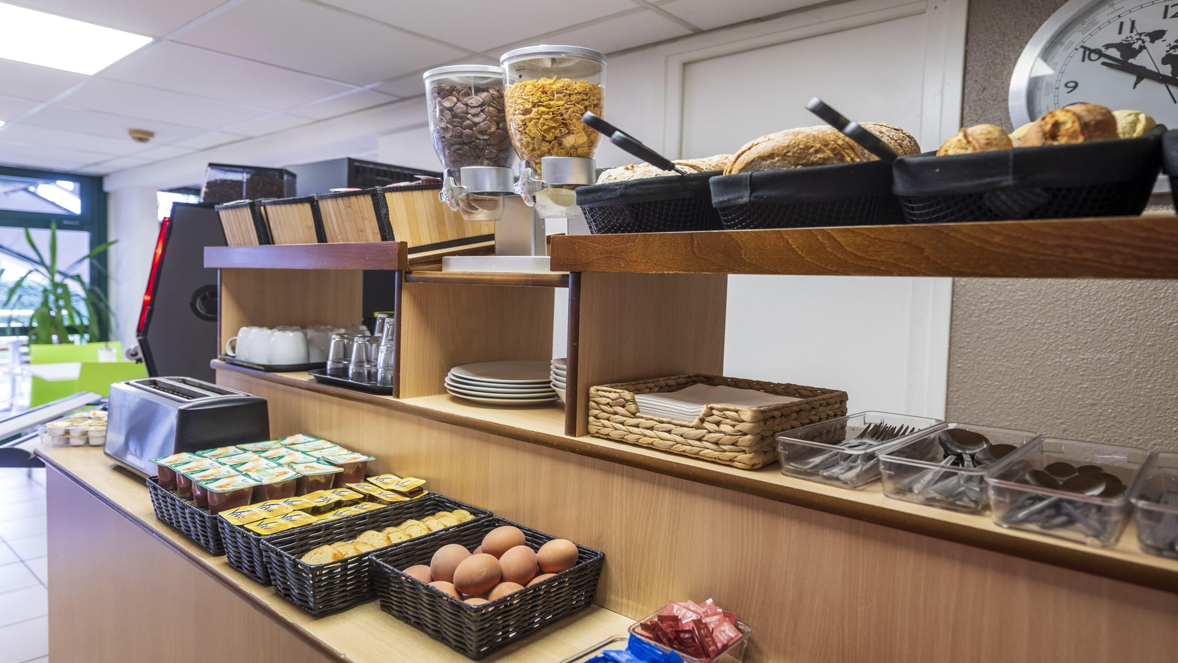 Un bufé de desayuno con diversas opciones de comida y una máquina de café.