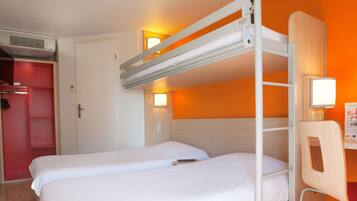 A bunk bed room with a desk and chair, a wardrobe, and a wall-mounted light.