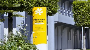 Ein gelbes Schild mit der Aufschrift "PREMIERE CLASSE HOTELS" und "BONNE ROUTE“, das ein Hotel namens "Bonne Route" kennzeichnet.