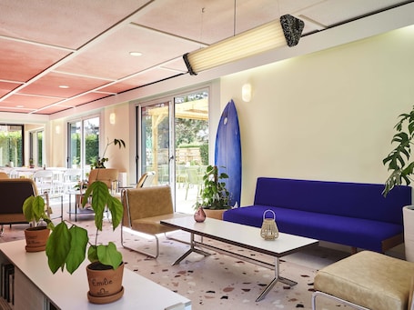 A modern indoor space with a blue sofa, a table, and potted plants.