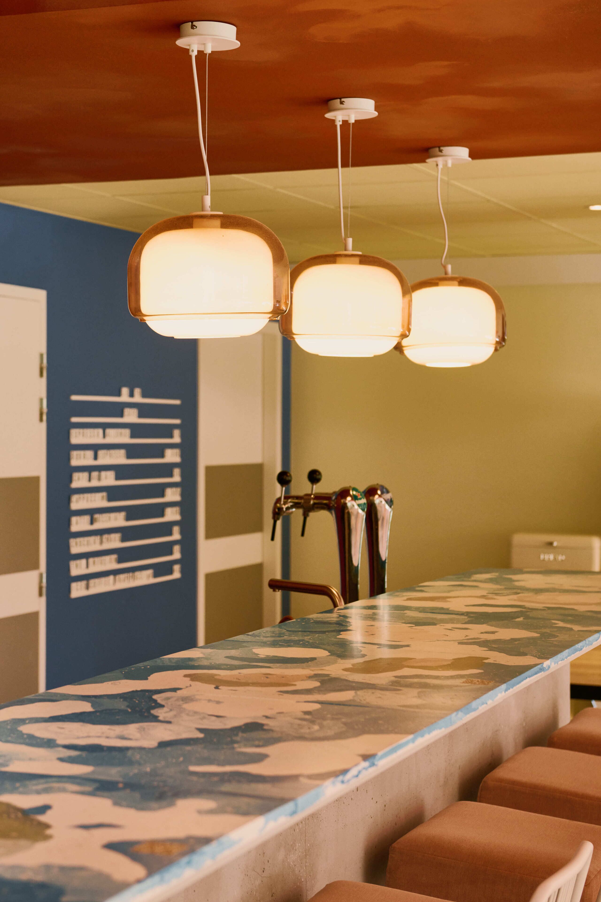 A bar area with a long counter and multiple seating options.