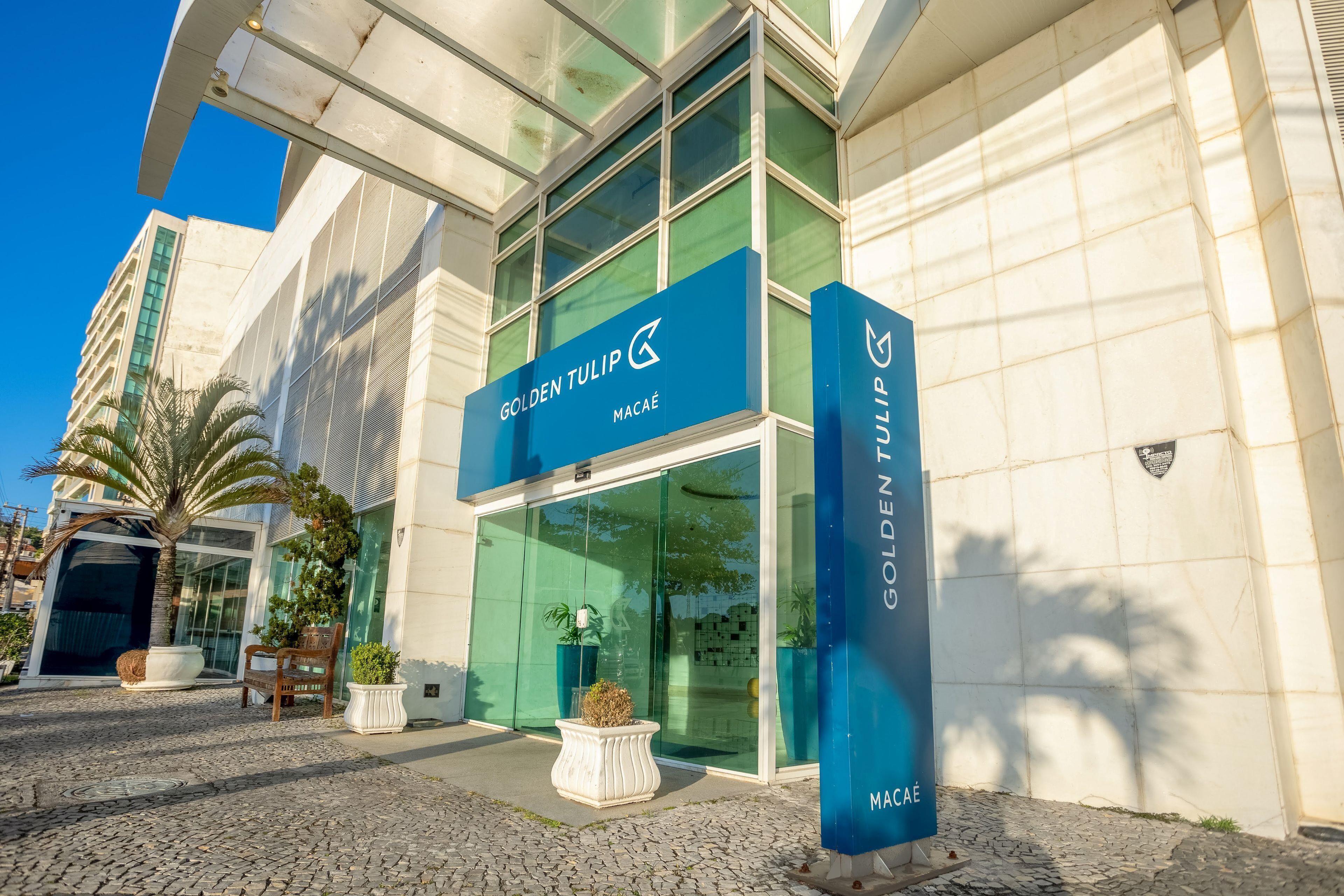 A modern building with a glass facade, labeled 'GOLDEN TULIP MACAE.'