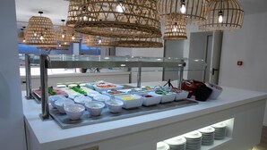 Een buffetgedeelte met diverse voedselcontainers en een glazen vitrine.