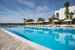 Piscine extérieure, parasols de plage, chaises longues