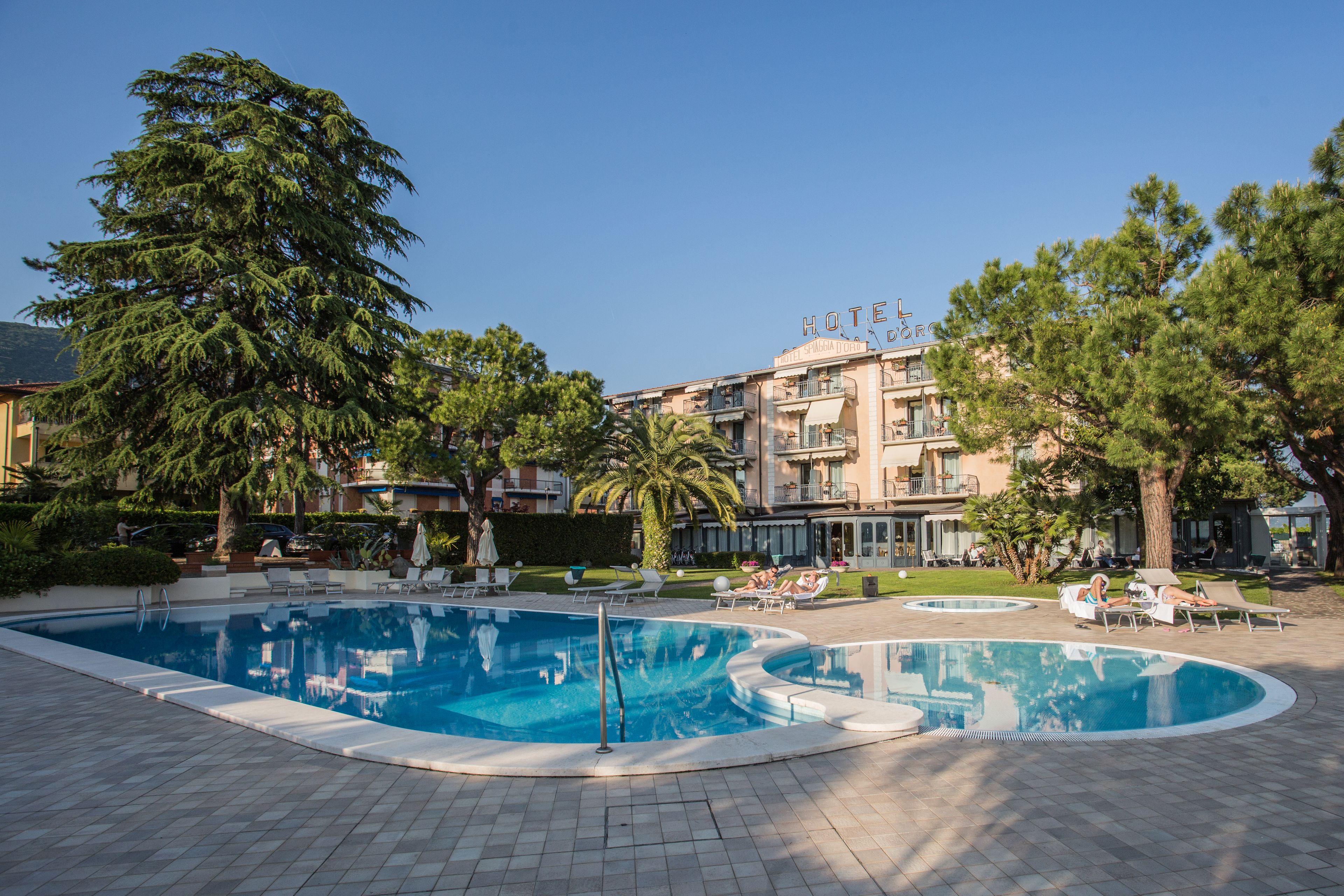 Ein Hotel mit Swimmingpool, Liegestühlen und blauem Himmel.