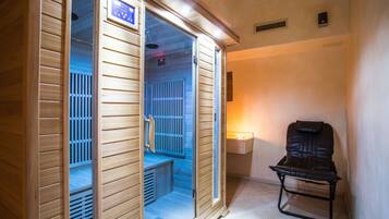 A sauna room with wooden walls, a bench, and a control panel.