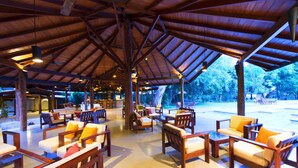 An outdoor seating area with wooden furniture and a covered roof structure.