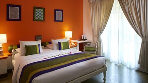 A hotel room with a large bed, two bedside tables, a chair, and a window with curtains.