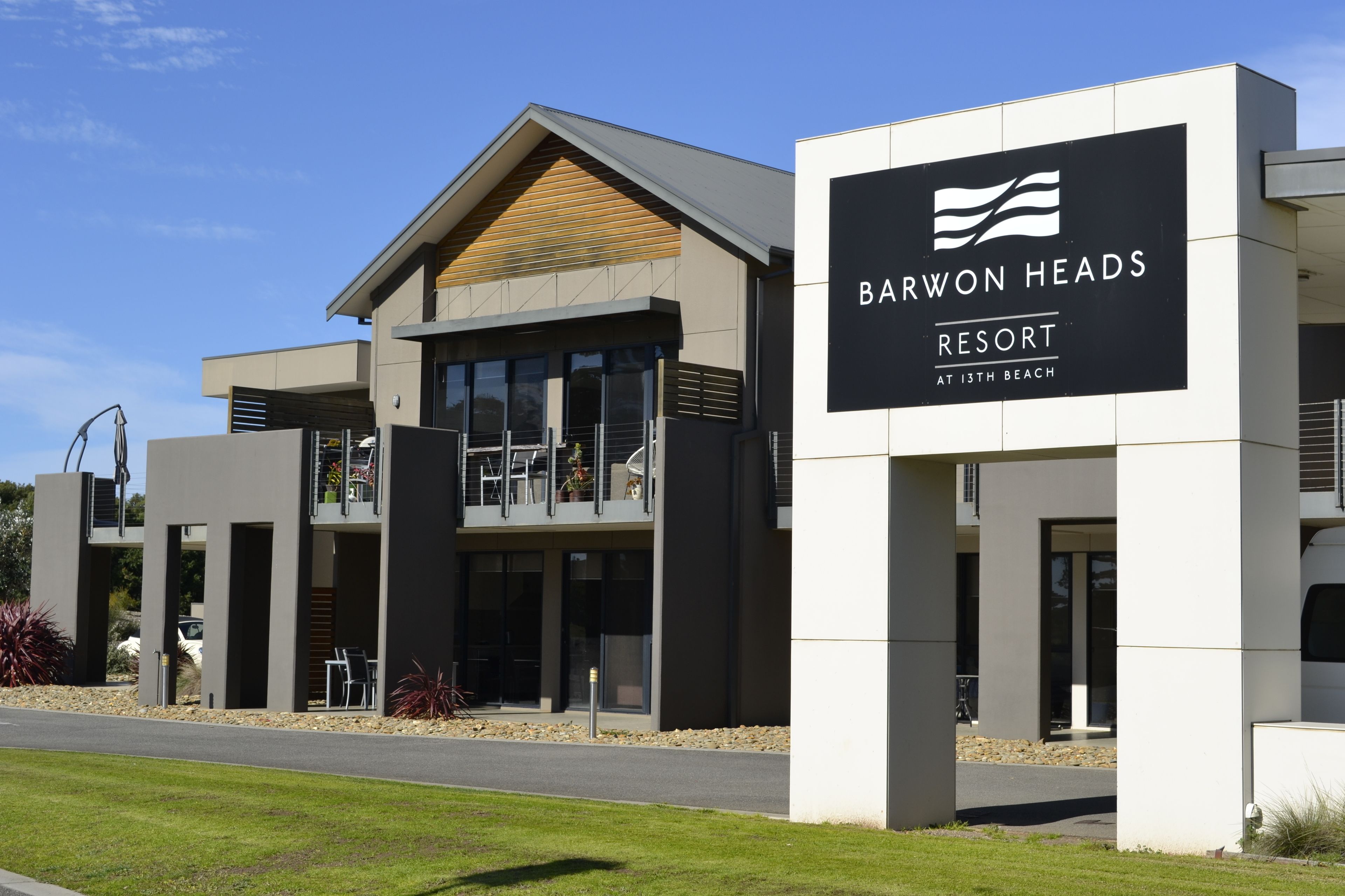 A modern resort building with a prominent sign for Barwon Heads Resort at 13th Beach.