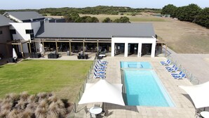 Un área junto a la piscina con sillones de descanso.