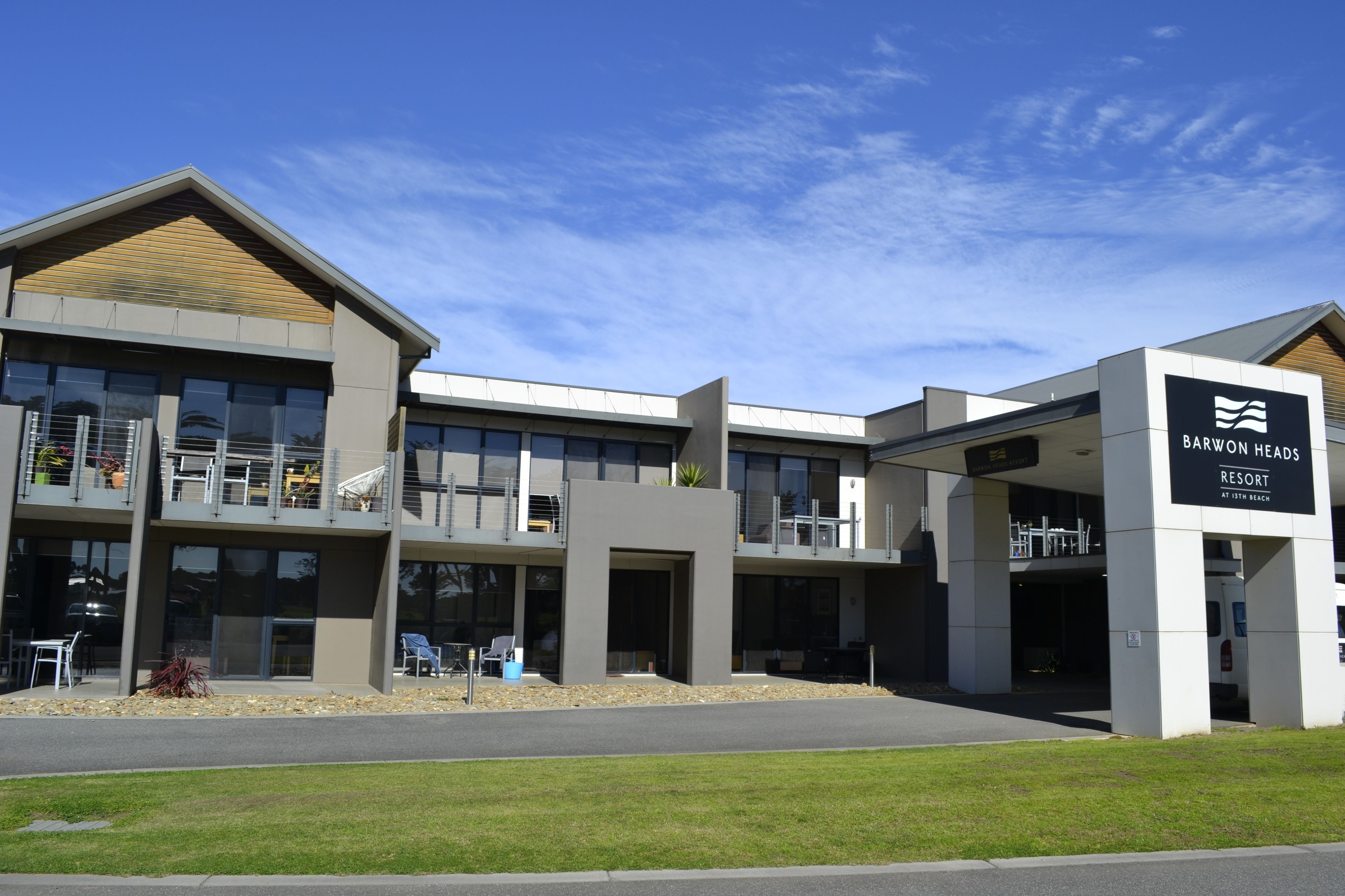 Ein modernes Gebäude mit einem Schild für das Barwon Heads Resort am Lister Beach.