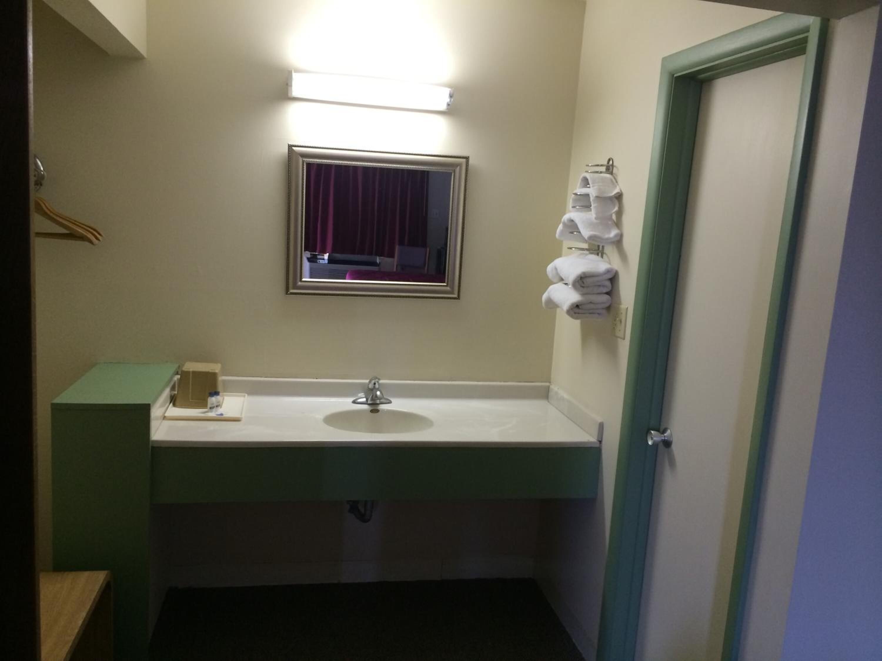 Une salle de bain équipée d’un lavabo, d’un miroir et d’un porte-serviettes.